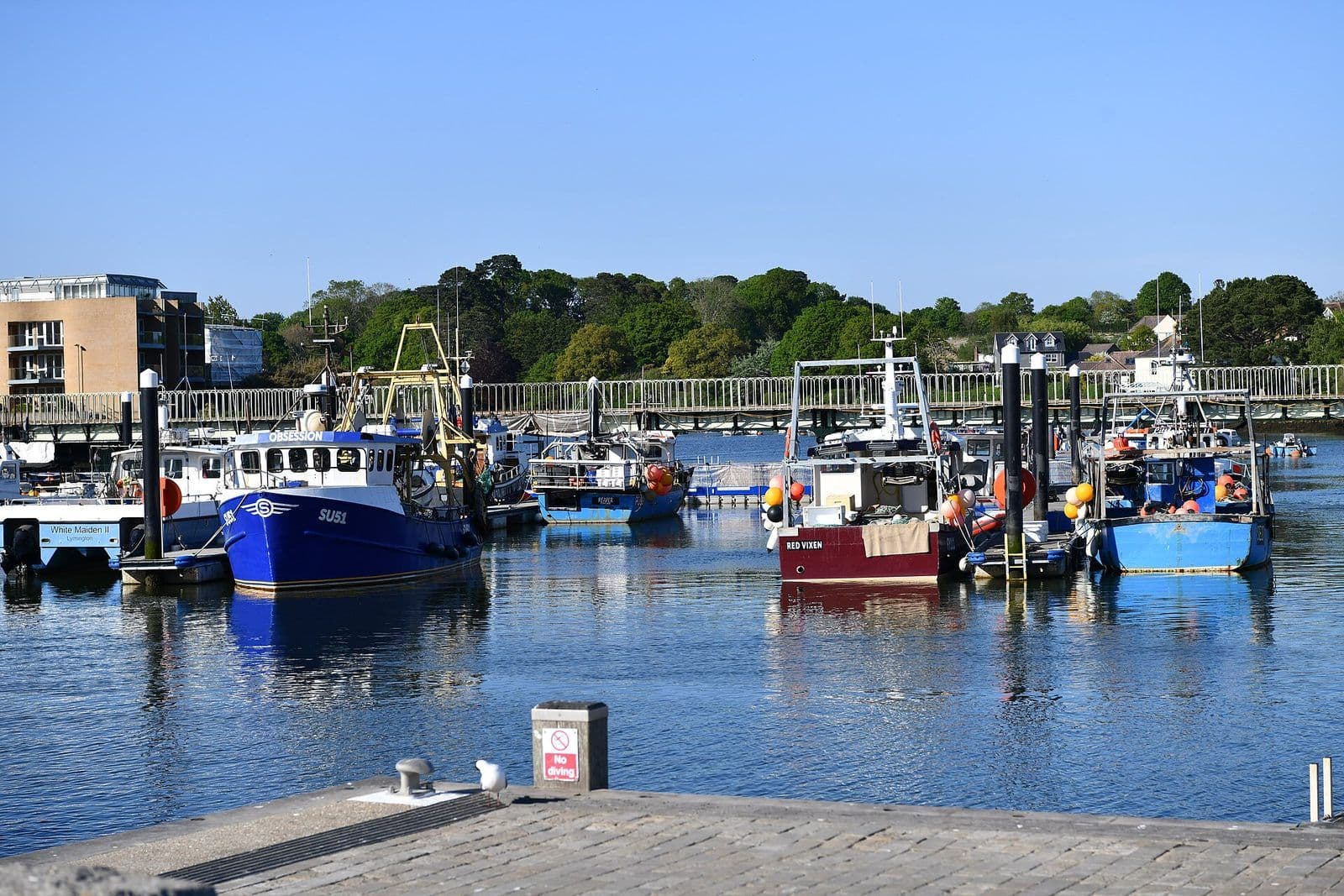 Fishing boats moored on the Lymington River beside the town quay on a sunny day